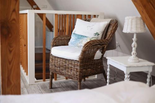 - Silla de mimbre con almohada en la habitación en Villa Miód Malina -Wisełka, en Wisełka