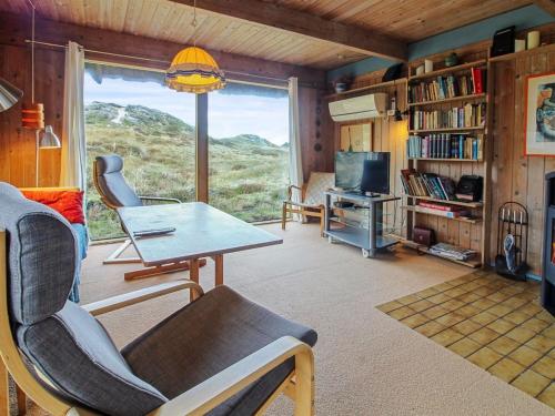 a living room with a table and chairs and a window at Holiday Home Asel - 1km from the sea by Interhome in Sønderho