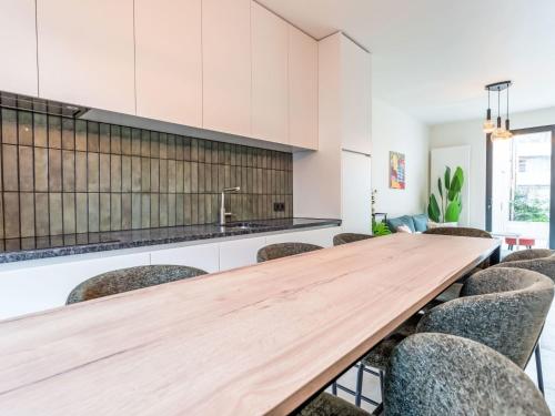 a large kitchen with a wooden table and chairs at Holiday Home Lili's with terrace by Interhome in Blankenberge