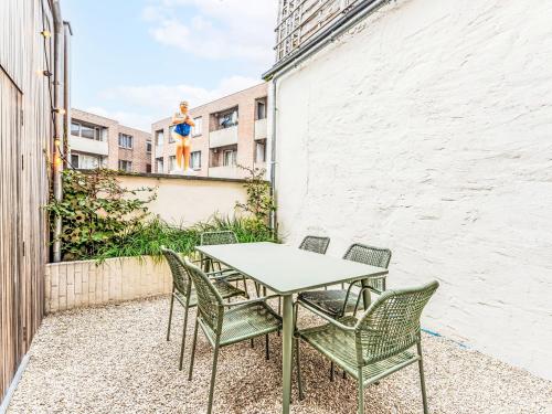 a table and chairs on a patio with a building at Holiday Home Lili's with terrace by Interhome in Blankenberge