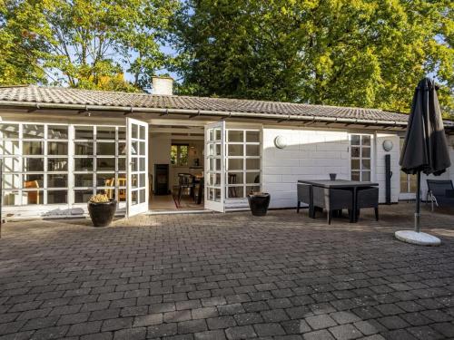 a patio with a table and an umbrella at Holiday Home Ranka - 300m from the sea by Interhome in Strøby Ladeplads