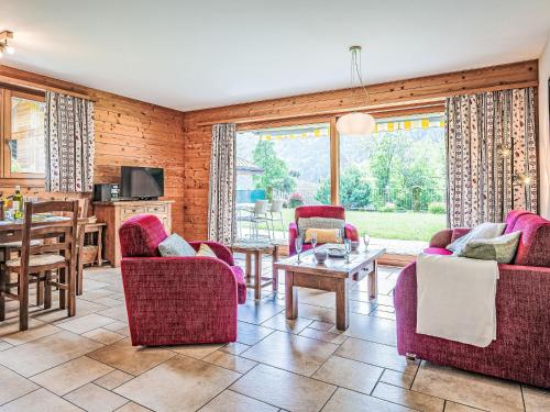 a living room with red chairs and a table at Apartment Rhodos A R03 by Interhome in Ovronnaz
