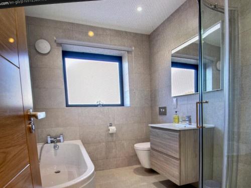 a bathroom with a tub and a toilet and a sink at Ten Admiralty Pier in Shotley Gate