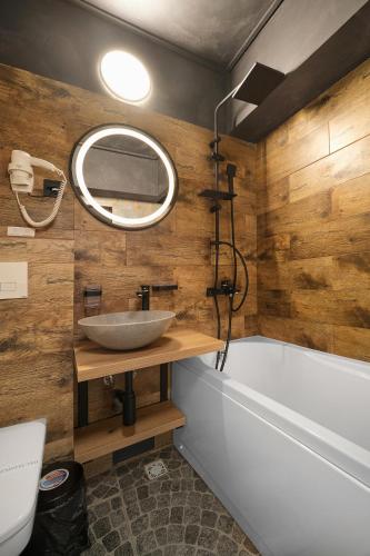 a bathroom with a sink and a tub and a mirror at Lapusneanu Central Apartments in Iaşi