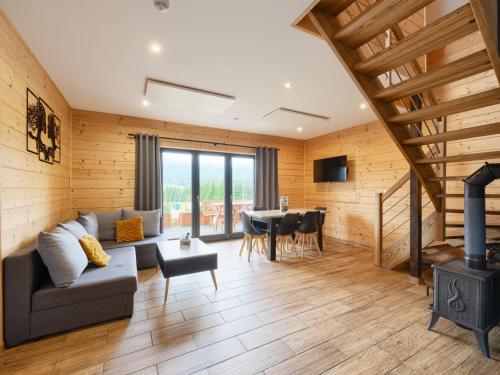 a living room with a couch and a stove at Chalet Osada Orlica by Interhome in Lasowka