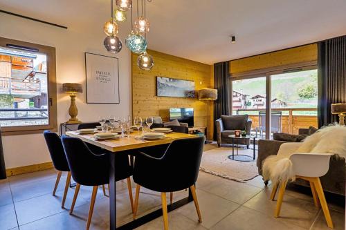 a dining room and living room with a table and chairs at Blanchets, Terrasse et confort 4 étoiles in Champagny-en-Vanoise