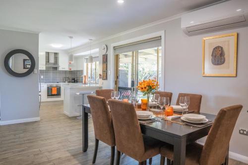 Un comedor y una cocina con mesa y sillas. en Stays with Ripley 3 min to hospital and beach Pet friendly, en Urraween
