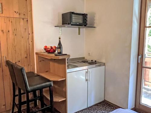 uma pequena cozinha com fogão e micro-ondas em Apartment Cheeky Apartment-2 by Interhome em Oberndorf in Tirol