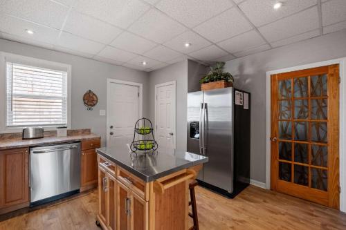 Una cocina con refrigerador de acero inoxidable y gabinetes de madera. en 1st Flr 1 Bed 1 Ba Furnished-Pet Friendly, en Manchester