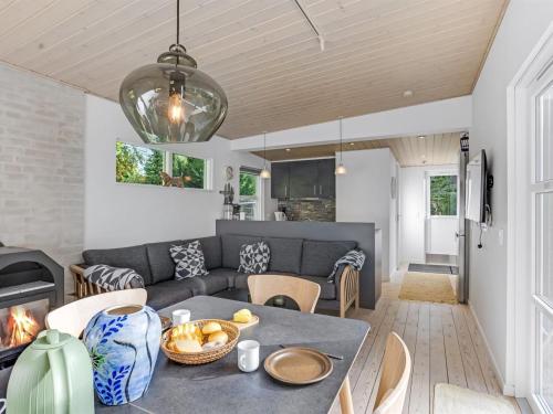 a living room with a table and a couch at Holiday Home Cornel - 300m from the sea by Interhome in Strøby Ladeplads