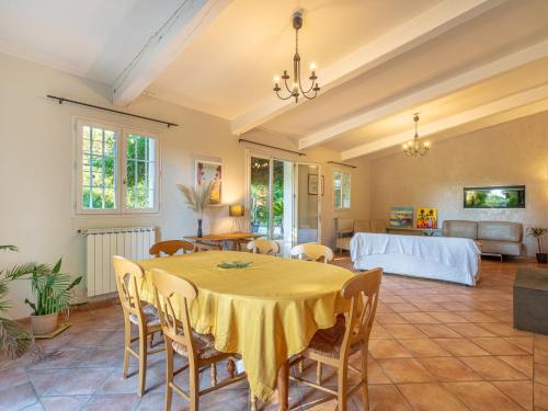 a dining room with a yellow table and chairs at Villa Palmeraie by Interhome in Hyères