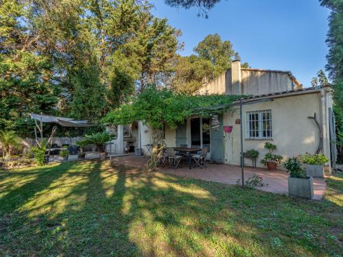 a house with a patio and a yard at Villa Palmeraie by Interhome in Hyères