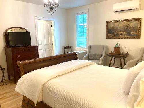 a bedroom with a bed and a flat screen tv at The Red House Fredericton in Fredericton