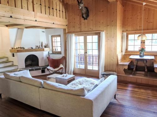 a living room with a couch and a fireplace at Chalet Spunda Biala by Interhome in Laax
