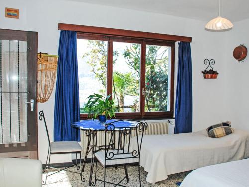 Habitación con mesa y ventana con cortinas azules. en Apartment App- 1 by Interhome, en Vairano