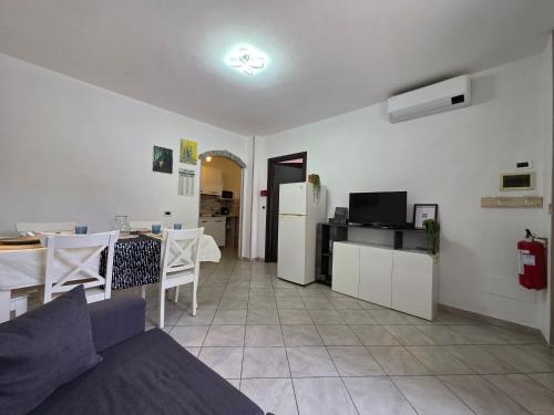 a living room with a couch and a table and a refrigerator at La tua Vacanza al Mare in Borghetto Santo Spirito