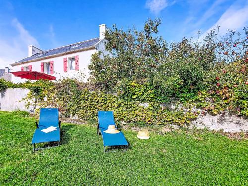 two blue chairs in the grass in front of a house at Holiday Home De cap en cap by Interhome in Trouguennour