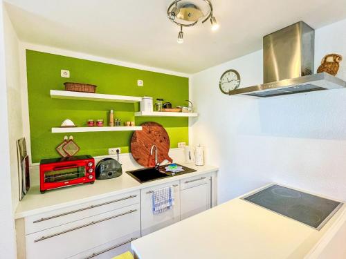 a kitchen with green walls and a counter with a microwave at Apartment Bärbel by Interhome in Suhl