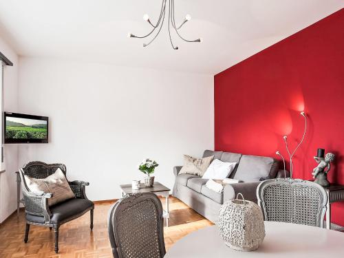 a living room with a couch and a red wall at Apartment Junior Suite-7 by Interhome in Ascona
