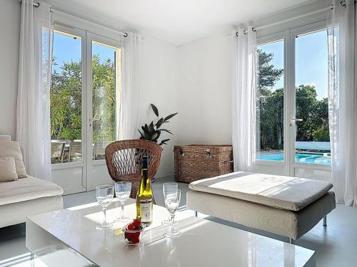 a white living room with a bottle of wine on a table at Holiday Home Ma Petite Mer by Interhome in Le Clion-sur-Mer