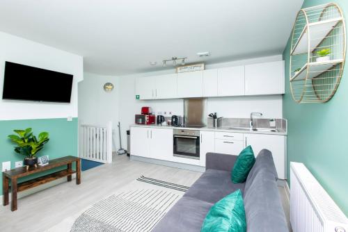 a living room with a couch and a kitchen at Carnforth 91 by Alt-Stay Contractor Accommodation - 2 Bed En-suite Contractor Home With Parking, Wi-Fi & Full Kitchen - Ideal For Long stays in Wakefield