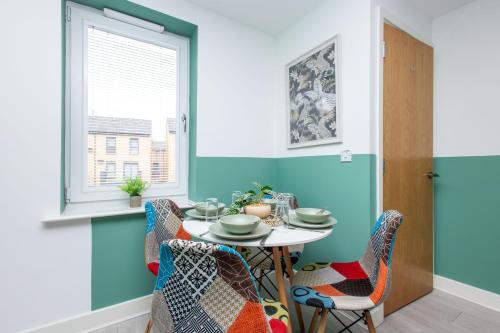 a dining room with a table and chairs at Carnforth 91 by Alt-Stay Contractor Accommodation - 2 Bed En-suite Contractor Home With Parking, Wi-Fi & Full Kitchen - Ideal For Long stays in Wakefield