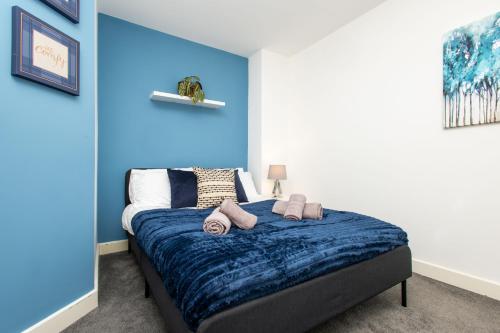 a bedroom with a blue wall and a bed at Carnforth 91 by Alt-Stay Contractor Accommodation - 2 Bed En-suite Contractor Home With Parking, Wi-Fi & Full Kitchen - Ideal For Long stays in Wakefield