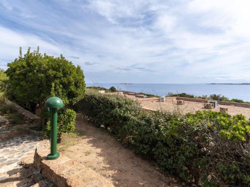 ein grüner Pfosten am Rand eines Weges in der Nähe des Ozeans in der Unterkunft Holiday Home Villa 20 by Interhome in SantʼAmanza