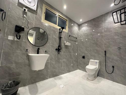 a bathroom with a toilet and a sink and a mirror at شقق وأستوديوهات فخمة Skyline luxurious Apartments and Studios Riyadh in Riyadh