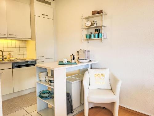 een keuken met een witte bar en een stoel bij Apartment Apt-Green View by Interhome in Locarno