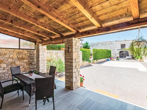 un patio con techo de madera, mesa y sillas en Holiday Home Marlen by Interhome, en Rovinjsko Selo