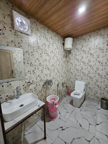 a bathroom with a sink and a toilet at Hotel Krishna And Restaurant in Sonprayag