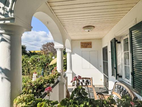 an arched porch with chairs and flowers on a house at Holiday Home Großmutters Ferienhaus by Interhome in Mörbisch am See