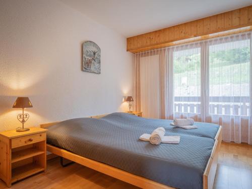 a bedroom with a bed with two towels on it at Apartment Sources 4110 by Interhome in Ovronnaz