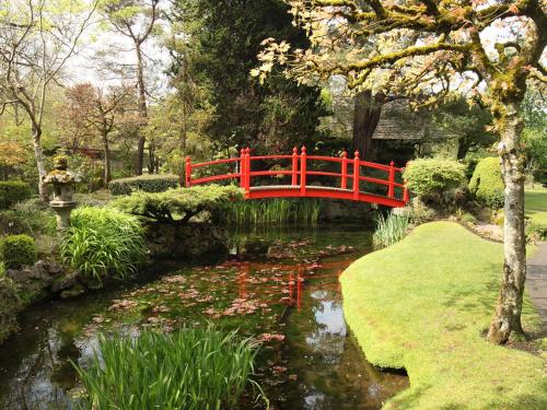a red bridge over a pond in a garden at Holiday Home Eagle View Holiday Home by Interhome in Moone