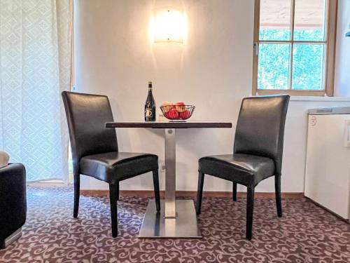 a table with two chairs and a bottle of wine at Apartment Cheeky Apartment-1 by Interhome in Oberndorf in Tirol
