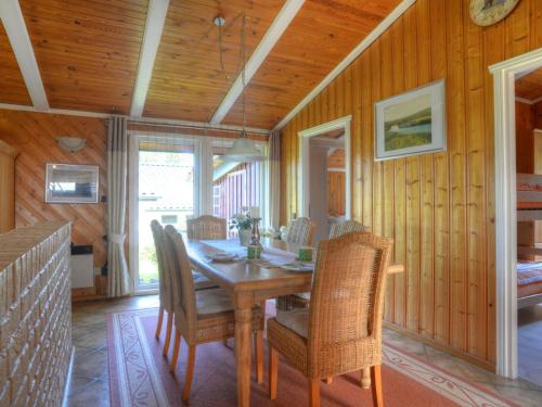 a dining room with a wooden table and chairs at Holiday Home Zedernhütte by Interhome in Bremke