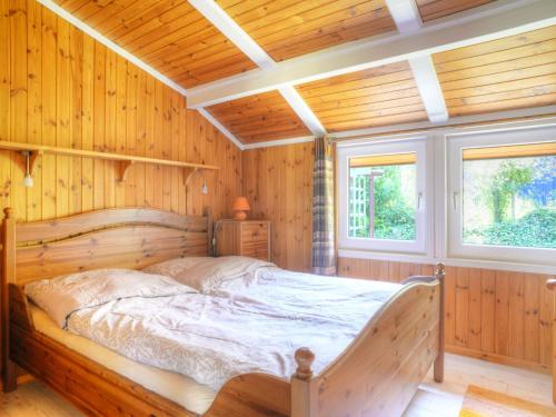 a bedroom with a bed in a room with wooden walls at Holiday Home Zedernhütte by Interhome in Bremke