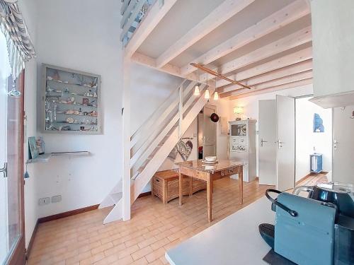 a living room with a table and a staircase at Holiday Home Les Charmilles-16 by Interhome in La Palmyre