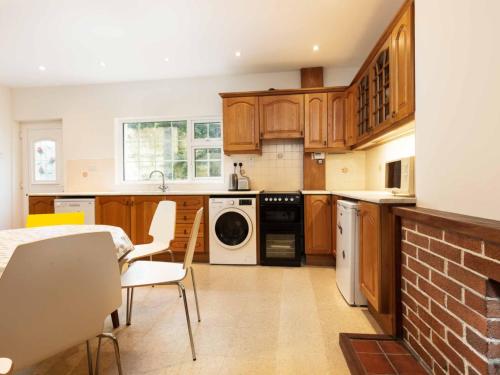 a kitchen with wooden cabinets and a brick wall at Holiday Home An Searrach Holiday Home Dingle by Interhome in Dingle