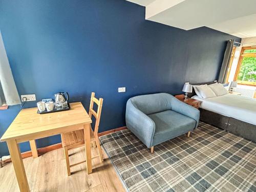 a room with a bed and a chair and a table at Studio Room 26 by Interhome in Nairn