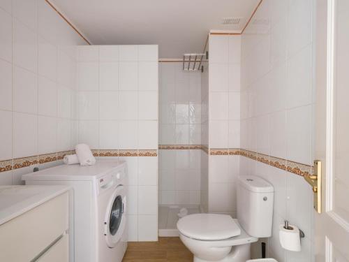 a white bathroom with a toilet and a washing machine at Marina nº 296 in Puerto de Mogán