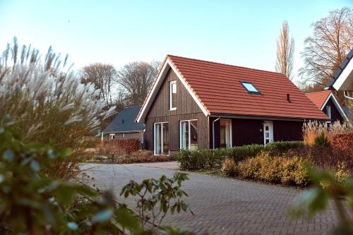 a house with a red roof and a driveway at Villapark Ehzerburg in Almen