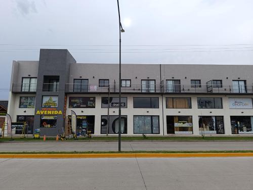 un immeuble d'appartements avec un balcon au-dessus dans l'établissement Departamento 25 de mayo Buenos Aires, à Veinticinco de Mayo