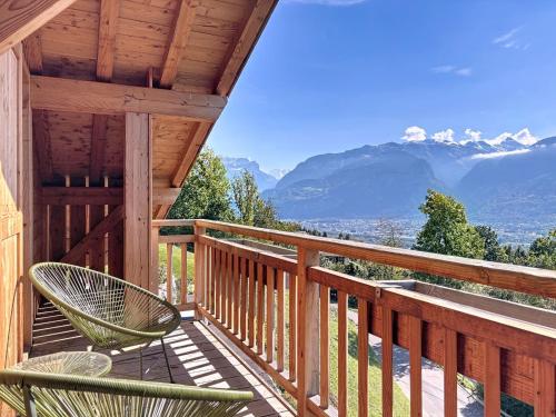 a wooden deck with chairs and a view of mountains at Chalet Chalet ECO by Interhome in Thyez