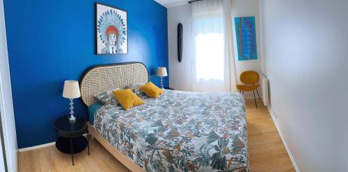 a bedroom with blue walls and a bed with yellow pillows at Charme et Douceur By UTA HOUSE in Saint-Denis