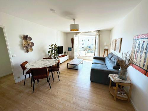 a living room with a blue couch and a table at Charme et Douceur By UTA HOUSE in Saint-Denis
