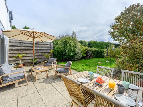 a patio with a table and chairs and an umbrella at Apartment Le nid du Golfe by Interhome in Mériadec