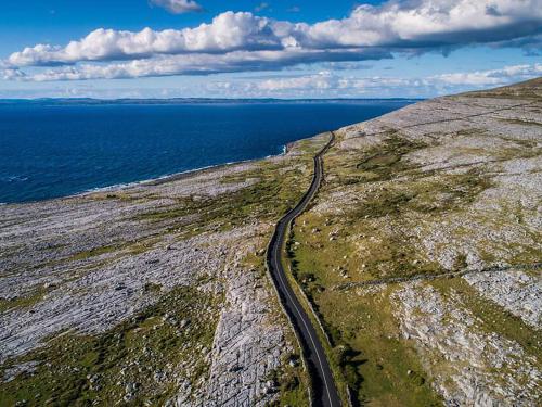 a road on the side of a cliff near the ocean at Holiday Home Burren Seaside Lodge by Interhome in Ballyvaughan