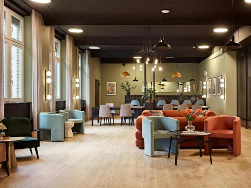 a waiting room with couches and tables and chairs at Numa Berlin Sketch in Berlin